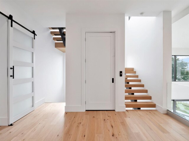 8157 Elion St, Orlando, FL 32827 - entryway featuring a barn door, light wood finished floors, and stairway