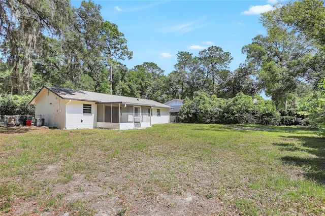 view of yard with a sunroom and central AC