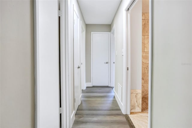 hallway featuring wood finished floors and baseboards