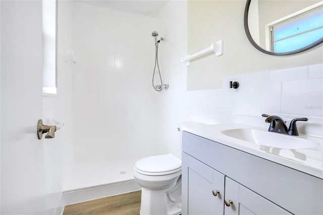 full bath with a stall shower, toilet, vanity, and wood finished floors