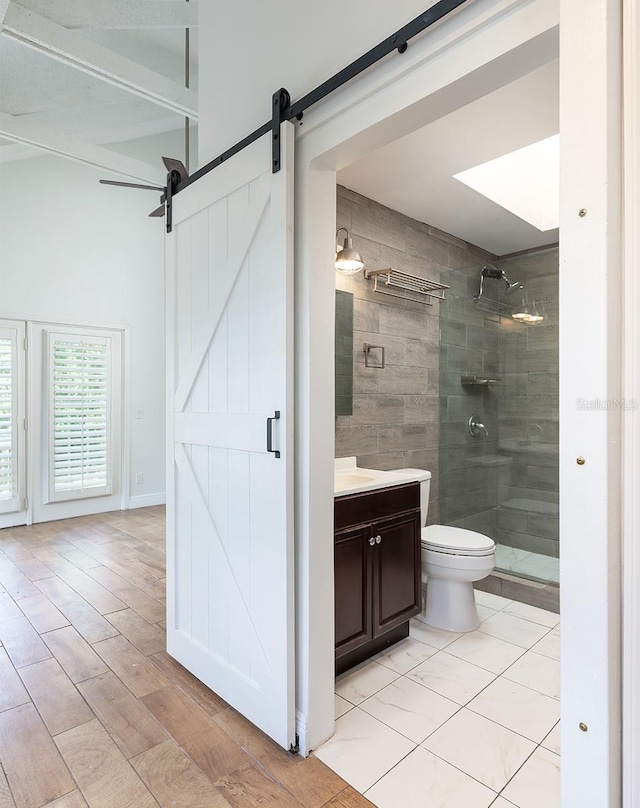 full bath featuring a shower stall, vanity, toilet, and wood finished floors