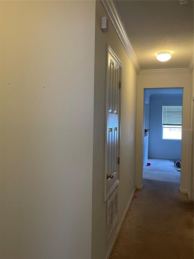 hallway with ornamental molding, carpet flooring, and baseboards