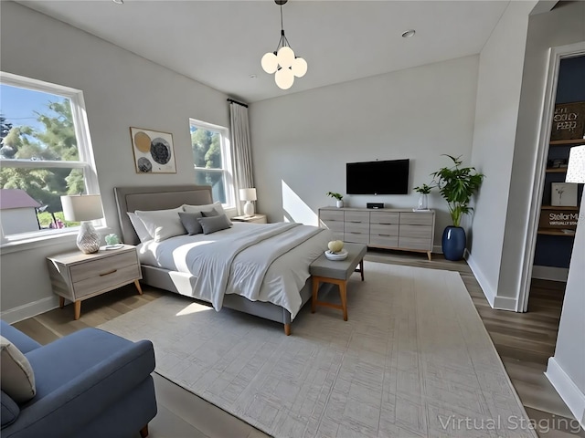 2336 SW 168th Loop, Ocala, FL 34473 - bedroom with baseboards, wood finished floors, and a chandelier