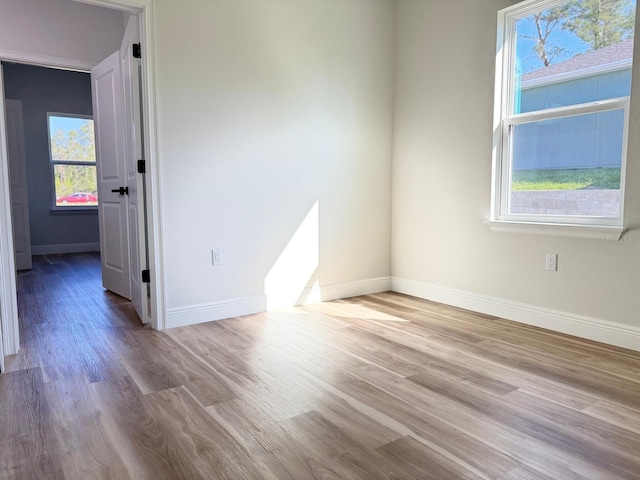 2336 SW 168th Loop, Ocala, FL 34473 - empty room featuring plenty of natural light, wood finished floors, and baseboards
