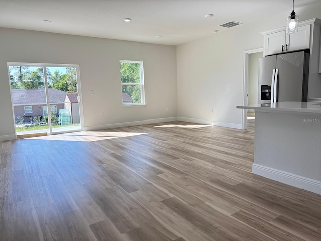 2336 SW 168th Loop, Ocala, FL 34473 - unfurnished living room with plenty of natural light, baseboards, light wood-style flooring, and recessed lighting