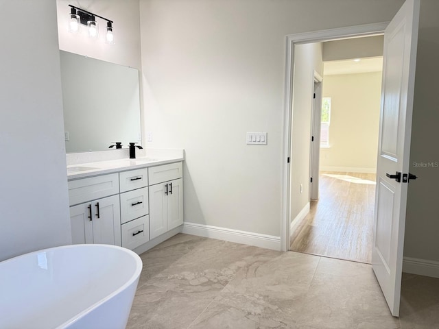 2336 SW 168th Loop, Ocala, FL 34473 - bathroom featuring double vanity, a freestanding bath, and baseboards