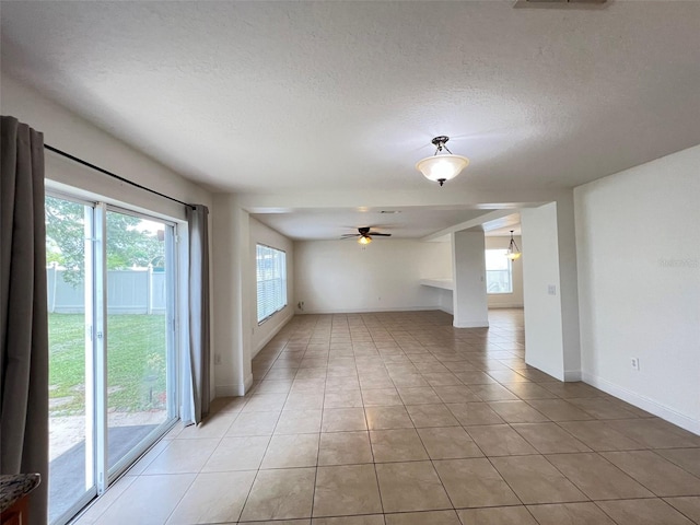1325 Bella Coola Dr, Orlando, FL 32828 - empty room with light tile patterned floors, a ceiling fan, and a textured ceiling