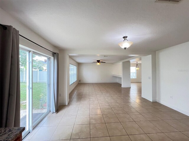 1325 Bella Coola Dr, Orlando, FL 32828 - empty room featuring plenty of natural light, light tile patterned flooring, ceiling fan, and a textured ceiling