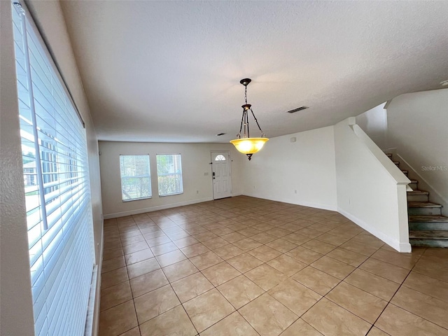 1325 Bella Coola Dr, Orlando, FL 32828 - unfurnished room featuring light tile patterned floors, stairs, and a textured ceiling