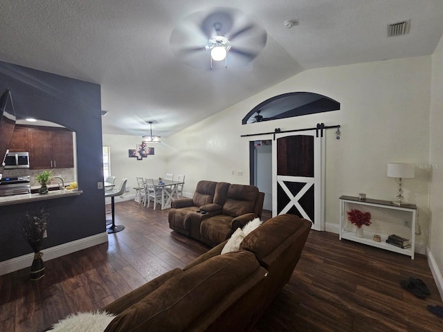 6436 Fig Leaf St, Magnolia Square, FL 34771 - living area with a barn door, a ceiling fan, vaulted ceiling, dark wood-type flooring, and baseboards