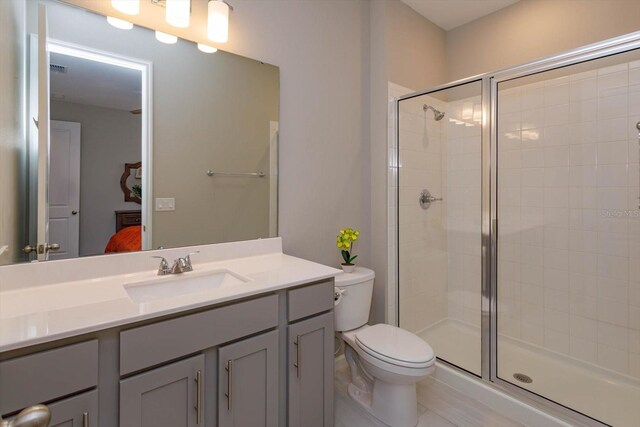 ensuite bathroom with a shower stall, toilet, and vanity