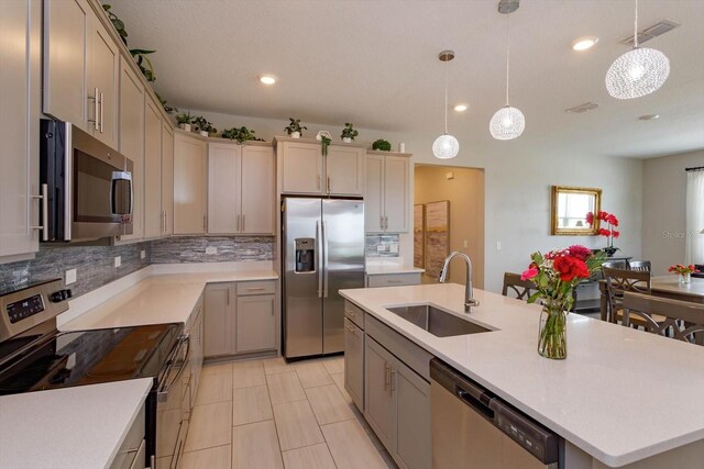 kitchen featuring appliances with stainless steel finishes, a sink, backsplash, light countertops, and recessed lighting
