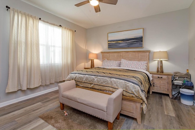 bedroom with wood finished floors, baseboards, and a ceiling fan