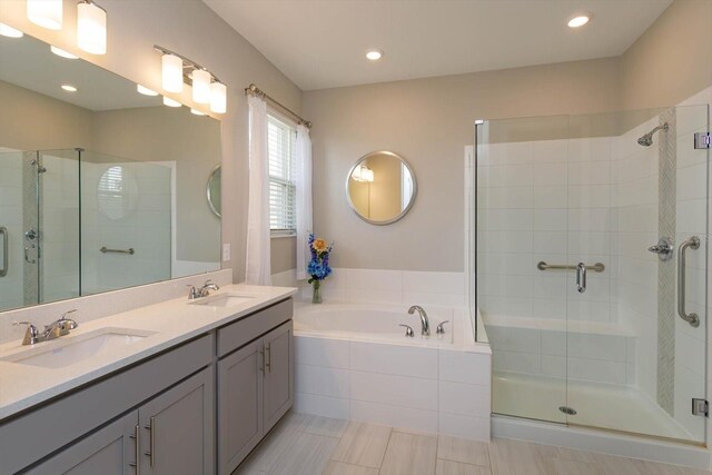 full bathroom featuring a shower stall, a bath, double vanity, and recessed lighting