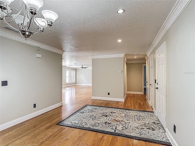 3234 Amberley Park Cir, Kissimmee, FL 34743 - unfurnished room with a textured ceiling, crown molding, wood finished floors, a chandelier, and recessed lighting