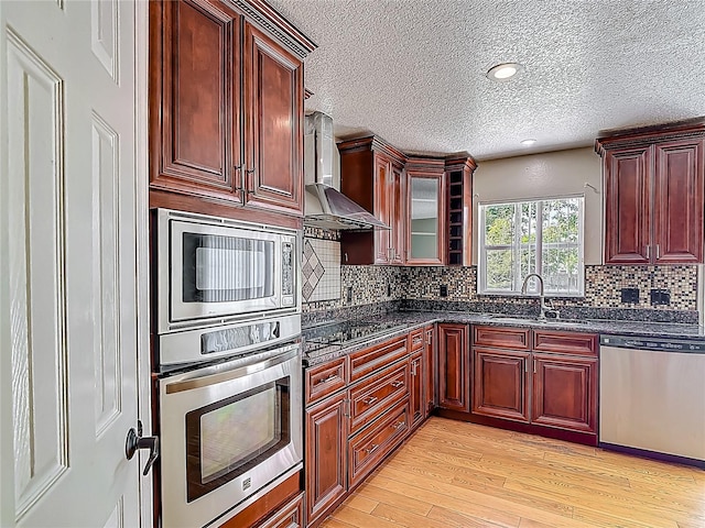 3234 Amberley Park Cir, Kissimmee, FL 34743 - kitchen with appliances with stainless steel finishes, a sink, wall chimney range hood, dark brown cabinets, and a textured ceiling