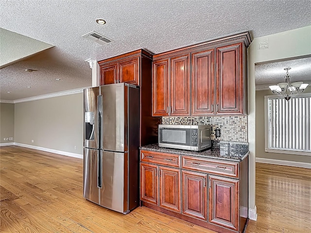 3234 Amberley Park Cir, Kissimmee, FL 34743 - kitchen with stainless steel appliances, a textured ceiling, light wood-type flooring, ornamental molding, and a chandelier