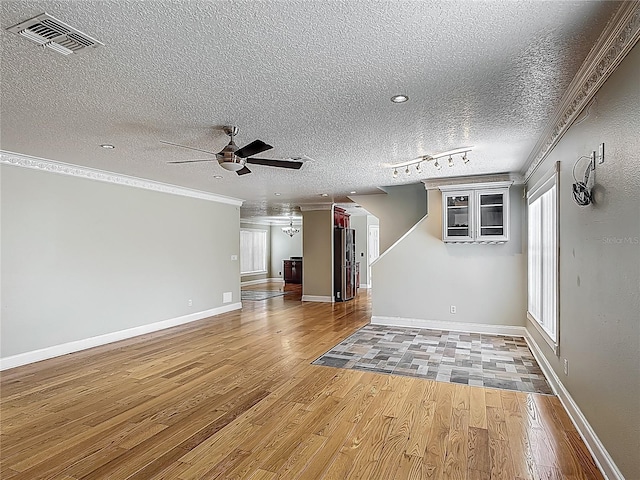 3234 Amberley Park Cir, Kissimmee, FL 34743 - unfurnished living room featuring ceiling fan, light wood finished floors, a textured ceiling, ornamental molding, and baseboards