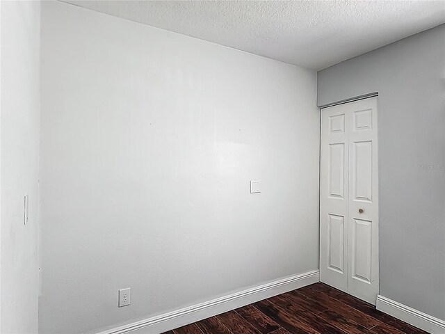 3234 Amberley Park Cir, Kissimmee, FL 34743 - spare room with dark wood-style flooring, baseboards, and a textured ceiling