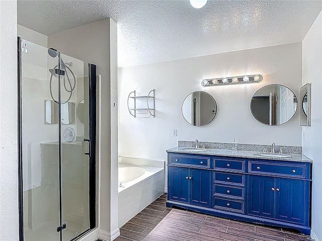 3234 Amberley Park Cir, Kissimmee, FL 34743 - full bathroom featuring wood tiled floors, a textured ceiling, a shower stall, a garden tub, and double vanity