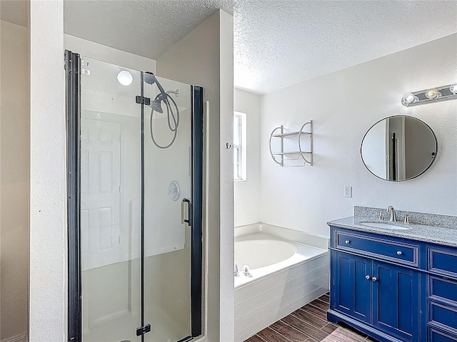 3234 Amberley Park Cir, Kissimmee, FL 34743 - full bath featuring a shower stall, a garden tub, a textured ceiling, vanity, and wood finished floors