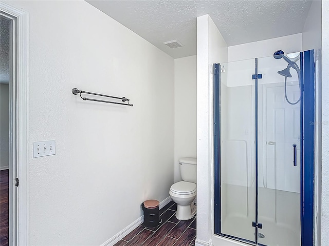 3234 Amberley Park Cir, Kissimmee, FL 34743 - bathroom featuring wood finish floors, a stall shower, a textured ceiling, toilet, and baseboards