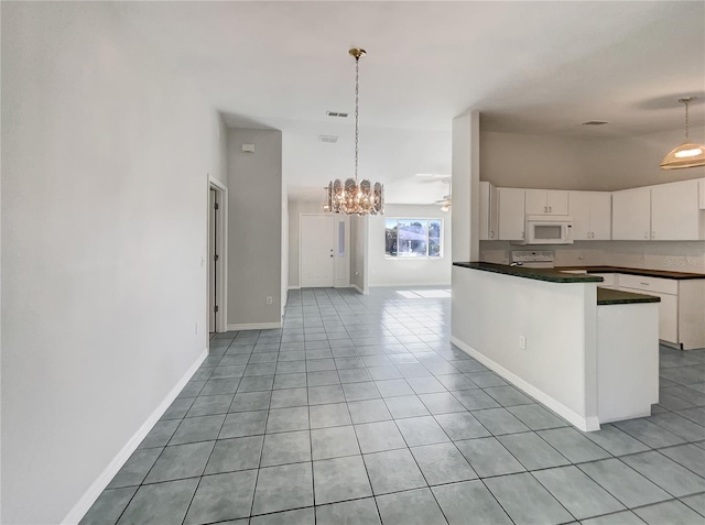 10350 SW 62nd Terrace Rd, Ocala, FL 34476 - kitchen featuring white microwave, dark countertops, white cabinets, light tile patterned floors, and a chandelier