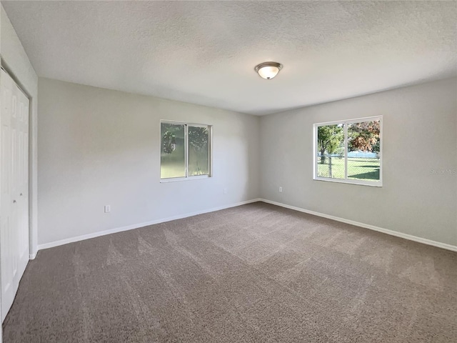 10350 SW 62nd Terrace Rd, Ocala, FL 34476 - spare room with dark carpet, a textured ceiling, and baseboards