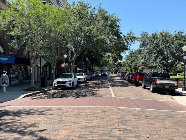 view of decorative road with street lighting, curbs, and sidewalks