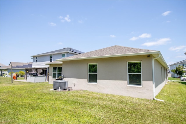 13851 Rushing Creek Run, Orlando, FL 32824 - back of property with stucco siding, a lawn, central AC, and roof with shingles