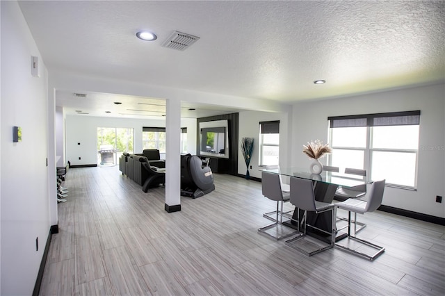 13851 Rushing Creek Run, Orlando, FL 32824 - dining space featuring a textured ceiling, baseboards, light wood-style floors, and recessed lighting