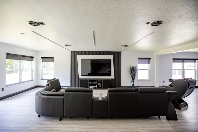 13851 Rushing Creek Run, Orlando, FL 32824 - living area featuring healthy amount of natural light, a textured ceiling, light wood-type flooring, and baseboards