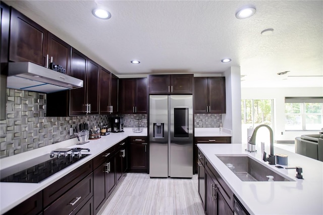 13851 Rushing Creek Run, Orlando, FL 32824 - kitchen with stainless steel refrigerator with ice dispenser, black electric stovetop, a sink, under cabinet range hood, and light countertops