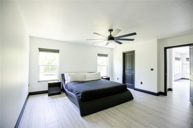 13851 Rushing Creek Run, Orlando, FL 32824 - bedroom featuring baseboards, a textured ceiling, a ceiling fan, and light wood-type flooring