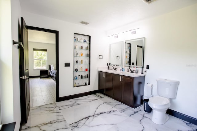 13851 Rushing Creek Run, Orlando, FL 32824 - full bath featuring connected bathroom, double vanity, baseboards, marble finish flooring, and toilet