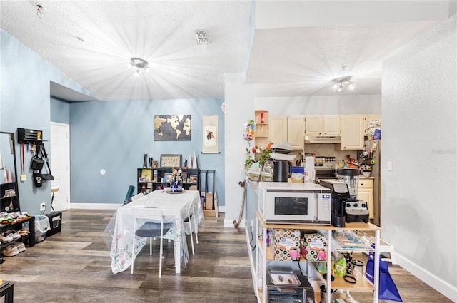 dining area featuring wood finished floors, baseboards, and a textured ceiling