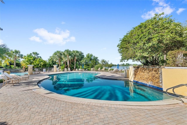community pool with a patio and fence