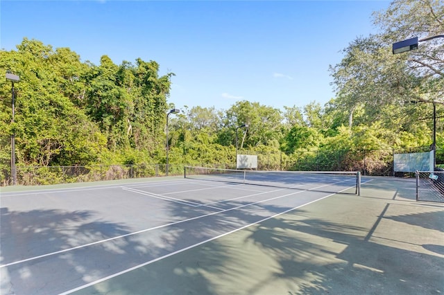 view of tennis court with fence and community basketball court