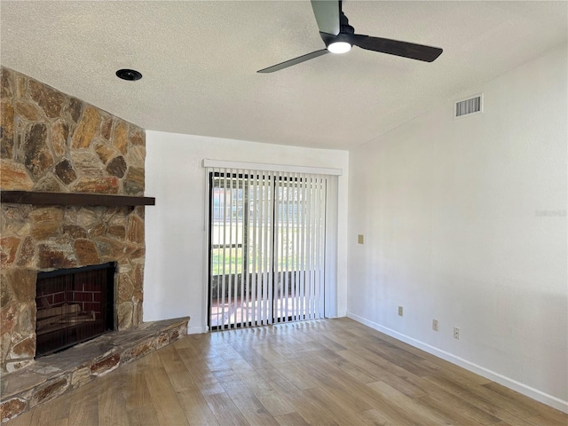 1825 Foxhall Cir Unit 1825, Kissimmee, FL 34741 - unfurnished living room featuring wood finished floors, ceiling fan, a textured ceiling, baseboards, and a fireplace