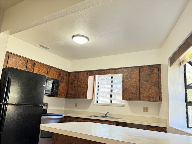 1825 Foxhall Cir Unit 1825, Kissimmee, FL 34741 - kitchen with black appliances, light countertops, a sink, and dark brown cabinetry