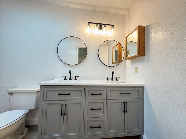1825 Foxhall Cir Unit 1825, Kissimmee, FL 34741 - bathroom with toilet, double vanity, baseboards, and a textured wall