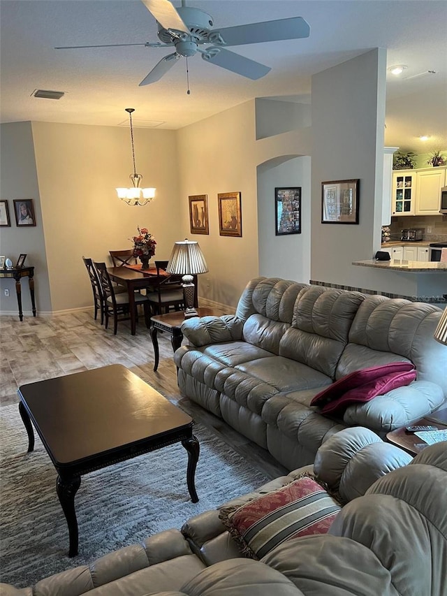 1121 Alcove Loop, The Villages, FL 32162 - living room featuring ceiling fan, arched walkways, a chandelier, and baseboards