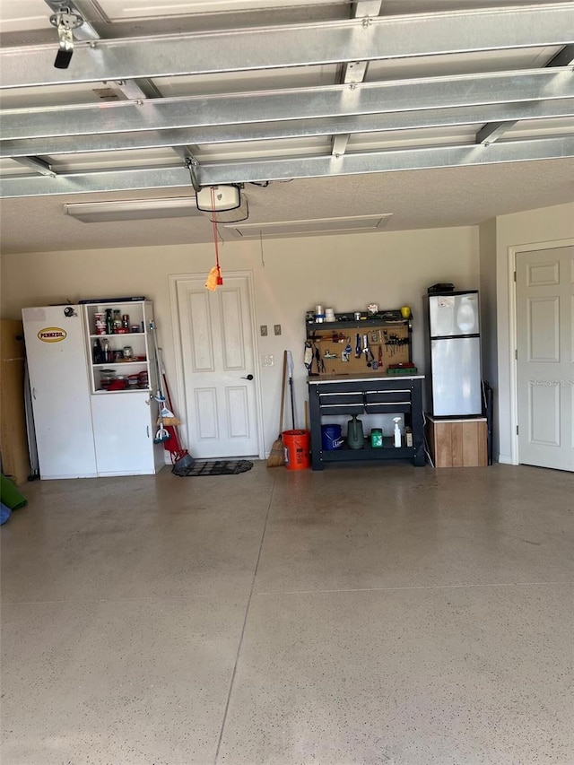 1121 Alcove Loop, The Villages, FL 32162 - garage with freestanding refrigerator, a garage door opener, and a workshop area
