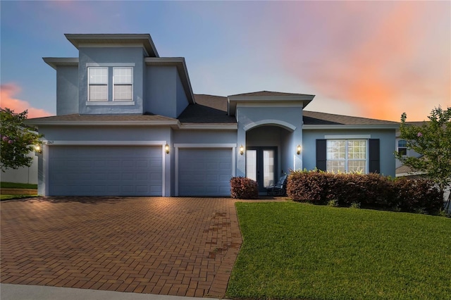 1265 Blarney St, Minneola, FL 34715 - view of front of house with stucco siding, decorative driveway, and a lawn