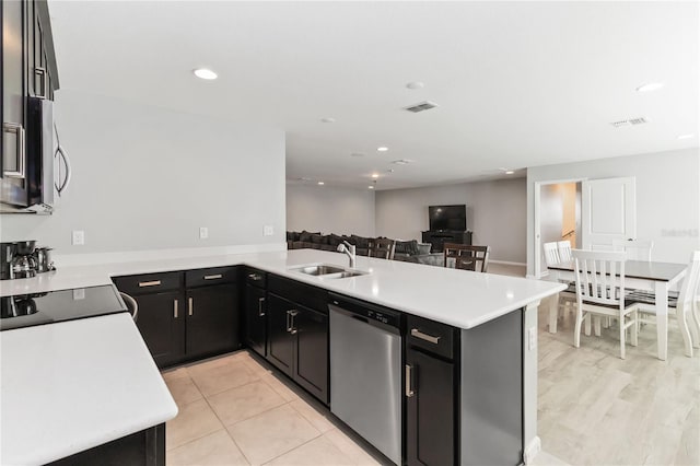 1265 Blarney St, Minneola, FL 34715 - kitchen with appliances with stainless steel finishes, a sink, light countertops, dark cabinetry, and a peninsula