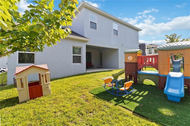 1265 Blarney St, Minneola, FL 34715 - rear view of house featuring a playground, stucco siding, a yard, and a patio