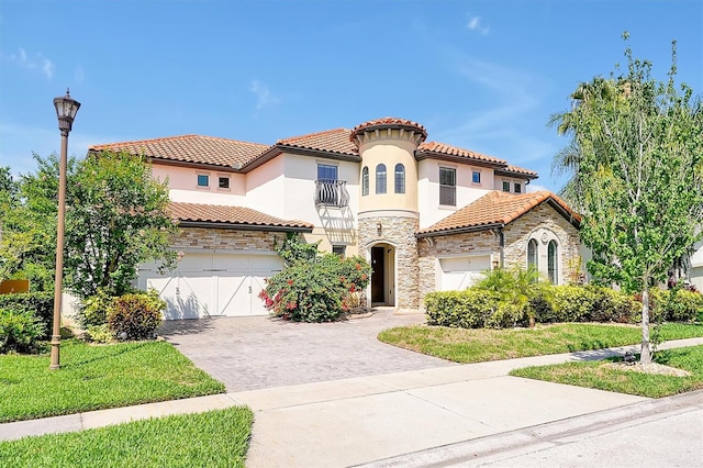 3844 Bowfin Trl, Kissimmee, FL 34746 - mediterranean / spanish home featuring a balcony, stone siding, decorative driveway, a tiled roof, and stucco siding