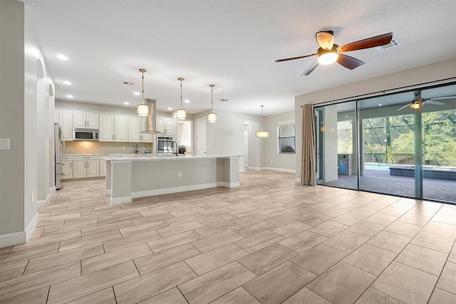 3844 Bowfin Trl, Kissimmee, FL 34746 - kitchen with appliances with stainless steel finishes, ceiling fan, open floor plan, island range hood, and recessed lighting