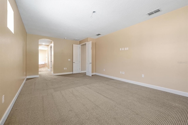 3844 Bowfin Trl, Kissimmee, FL 34746 - unfurnished room with arched walkways, carpet floors, baseboards, and a textured ceiling