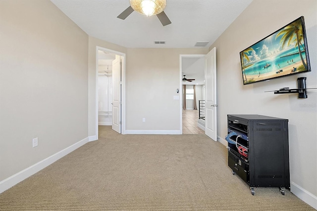3844 Bowfin Trl, Kissimmee, FL 34746 - bedroom with light colored carpet, baseboards, a ceiling fan, and connected bathroom